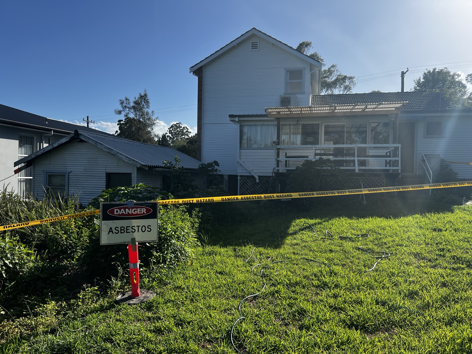 Weatherboard residence behind danger asbestos exclusion zone before friable removal works