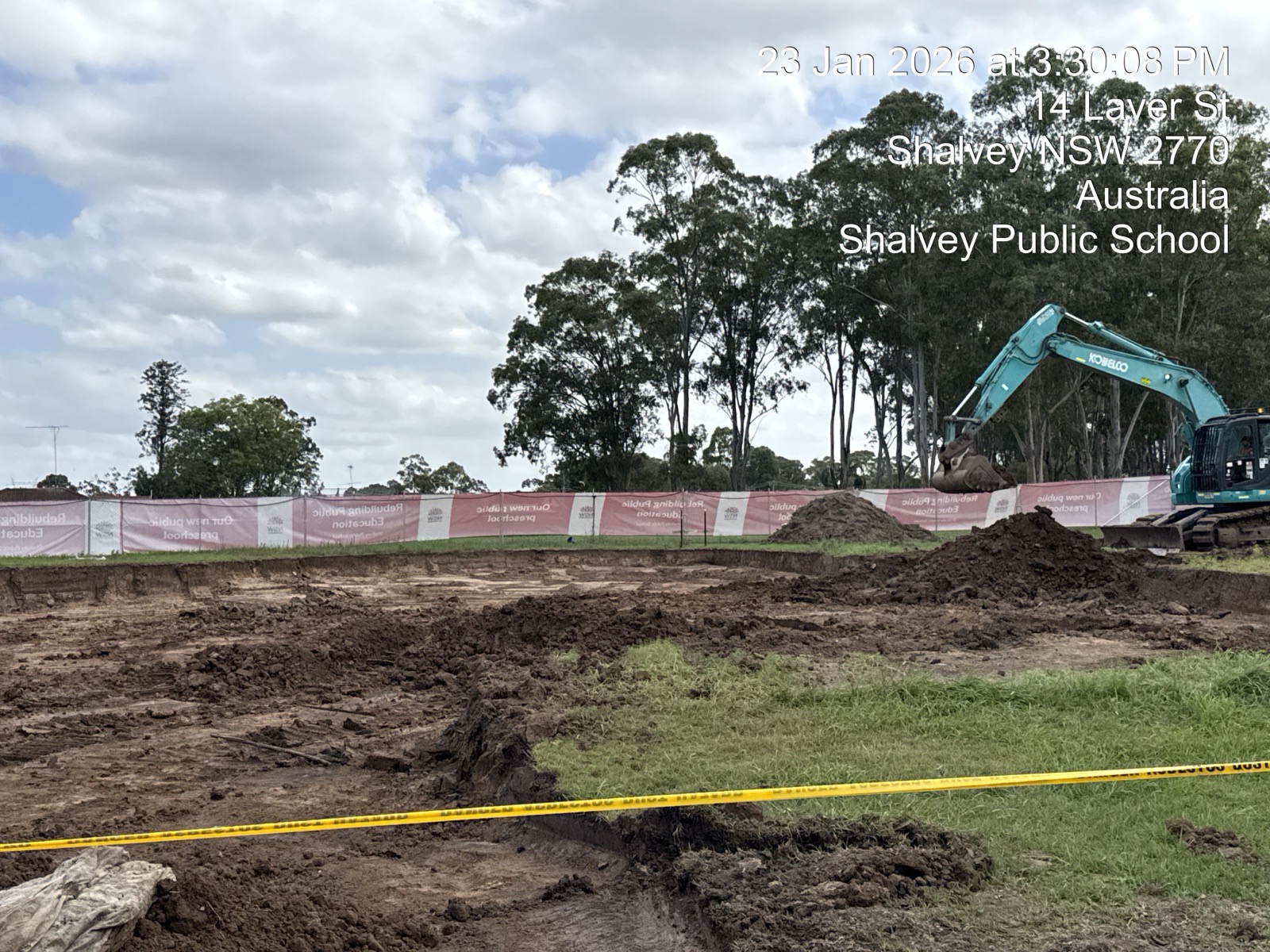 Excavator remediating contaminated soil behind hazard tape, Shalvey Public School